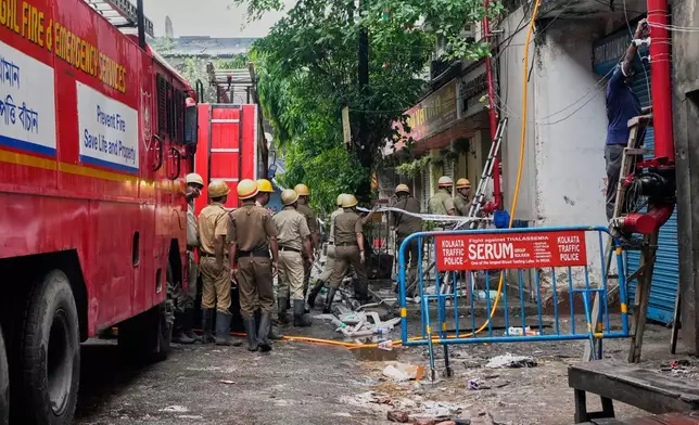 Firefighters inspect a hotel building which caught fire on Tuesday resulting in several deaths, in Kolkata, India, Wednesday, April 30, 2025. (AP Photo/Bikas Das)