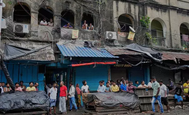 Local people gather in front of a hotel building which caught fire on Tuesday resulting in several deaths, in Kolkata, India, Wednesday, April 30, 2025. (AP Photo/Bikas Das)