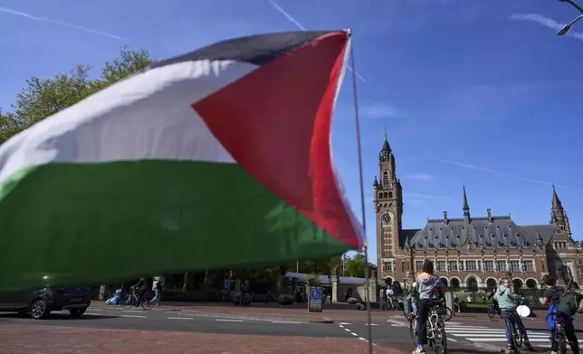 A Palestinian flag flies outside the International Court of Justice, rear, which opened hearings into a United Nations request for an advisory opinion on Israel's obligations to allow humanitarian assistance in Gaza and the West Bank, in The Hague, Netherlands, Monday, April 28, 2025. (AP Photo/Peter Dejong)