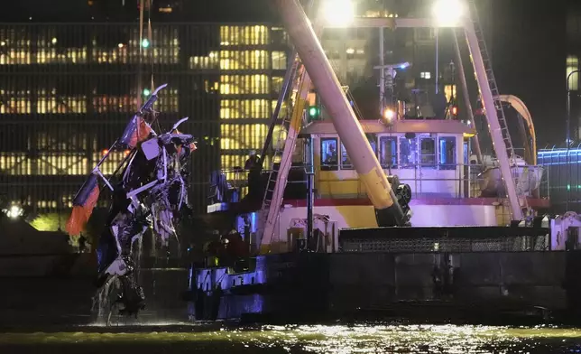 A crane vessel lifts the wreckage of a helicopter that crashed into the Hudson River, Thursday, April 10, 2025, in Jersey City, N.J. (AP Photo/Seth Wenig)