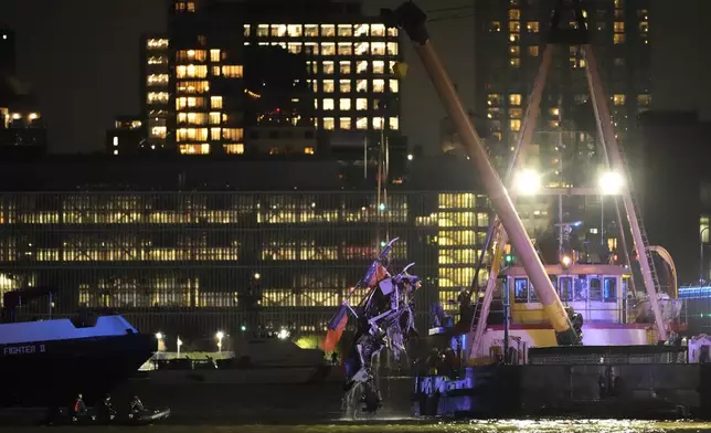 A crane vessel lifts the wreckage of a helicopter that crashed into the Hudson River, Thursday, April 10, 2025, in Jersey City, N.J. (AP Photo/Seth Wenig)