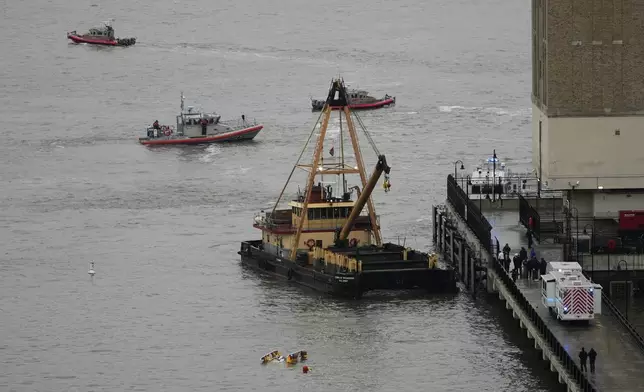 A crane vessel arrives at the scene where a helicopter crashed into the Hudson River, Thursday, April 10, 2025, in Jersey City, N.J. (AP Photo/Seth Wenig)
