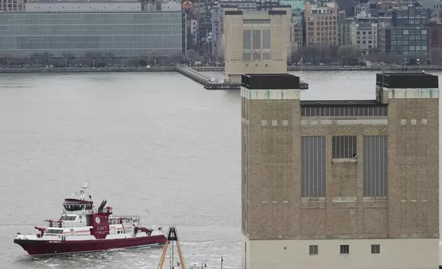 First responders from New Jersey and New York look on as a crane vessel arrives at the scene where a helicopter crashed into the Hudson River, Thursday, April 10, 2025, in Jersey City, N.J. (AP Photo/Seth Wenig)