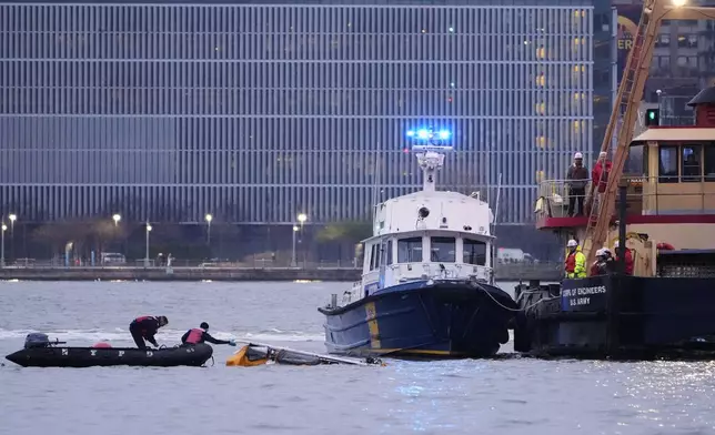 Divers investigate the scene where a helicopter crashed into the Hudson River, Thursday, April 10, 2025, in Jersey City, N.J. (AP Photo/Seth Wenig)