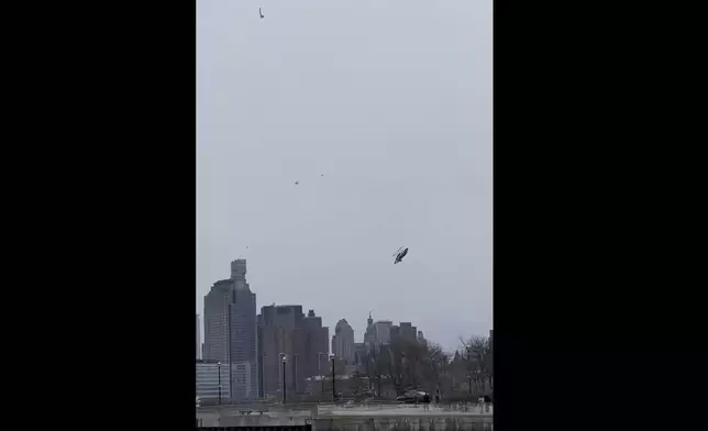 In this photo taken from video, a helicopter falls from the sky into the Hudson River , Thursday, April 10, 2025, in Jersey City, N.J. (Bruce Wall via AP)