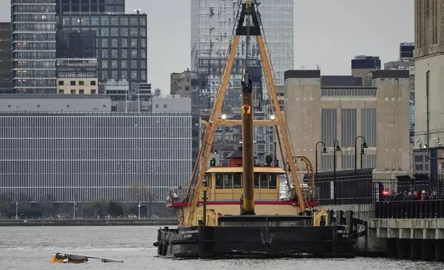 A crane vessel sits docked at the scene where a helicopter crashed into the Hudson River, Thursday, April 10, 2025, in Jersey City, N.J. (AP Photo/Seth Wenig)