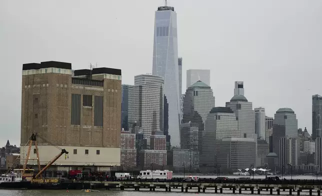 First responders stand on a pier at the scene where a helicopter crashed into the Hudson River, Thursday, April 10, 2025, in Jersey City, N.J. (AP Photo/Seth Wenig)