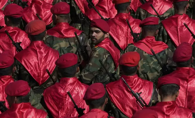 An Iranian army member, center, looks back, among others, as they conclude their march, during a parade commemorating National Army Day in front of the shrine of the late revolutionary founder Ayatollah Khomeini, just outside Tehran, Iran, Friday, April 18, 2025. (AP Photo/Vahid Salemi)