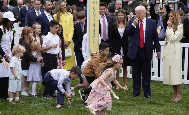 President Donald Trump and first lady Melania Trump blow whistles during the White House Easter Egg Roll on the South Lawn of the White House, Monday, April 21, 2025, in Washington. (AP Photo/Alex Brandon)