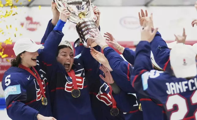 United States' players celebrate with a trophy after the gold medal match between Canada and the United States at the Women's Ice Hockey Championships in Ceske Budejovice, Czech Republic, Sunday, April 20, 2025. (AP Photo/Petr David Josek)