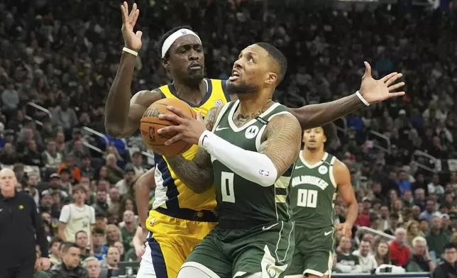 Milwaukee Bucks guard Damian Lillard (0) drives to the basket against Indiana Pacers forward Pascal Siakam, left, during the first half in Game 3 of an NBA basketball first-round playoff series Friday, April 25, 2025, in Milwaukee. (AP Photo/Nam Y. Huh)