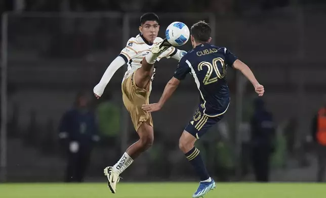 Piero Quispe of Mexico's Pumas, left, and Andres Cubas of Canada's Vancouver Whitecaps vie for the ball during a CONCACAF Champions Cup second leg quarterfinal soccer match in Mexico City, Wednesday, April 9, 2025. (AP Photo/Eduardo Verdugo)