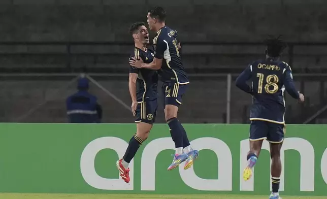 Sebastian Berhalter of Canada's Vancouver Whitecaps, left, celebrates scoring his side's opening goal with teammate Ranko Veselinovic against Mexico's Pumas during a CONCACAF Champions Cup second leg quarterfinal soccer match in Mexico City, Wednesday, April 9, 2025. (AP Photo/Eduardo Verdugo)