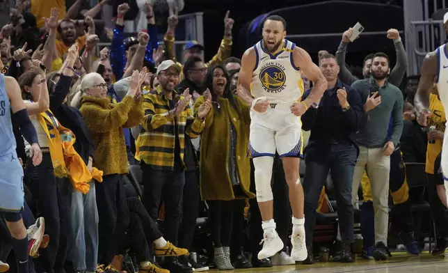 Fans react as Golden State Warriors guard Stephen Curry (30) celebrates after making a 3-point basket during the second half of an NBA play-in tournament basketball game against the Memphis Grizzlies in San Francisco, Tuesday, April 15, 2025. (AP Photo/Jeff Chiu)