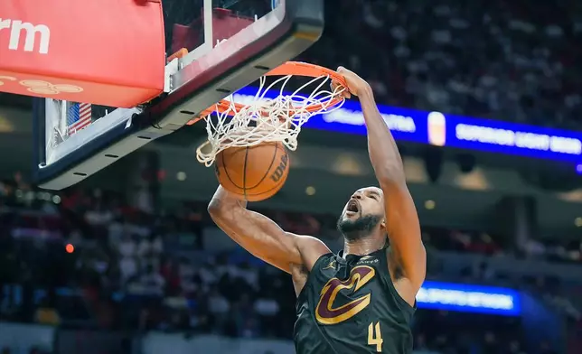 Cleveland Cavaliers forward Evan Mobley (4) scores against the Miami Heat during the second half in Game 3 of an NBA basketball first-round playoff series, Saturday, April 26, 2025, in Miami. (AP Photo/Michael Laughlin)