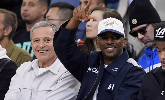 Chris Paul, right, gestures as Bob Iger looks on during the first half in Game 3 of an NBA basketball first-round playoff series between the Los Angeles Clippers and the Denver Nuggets, Thursday, April 24, 2025, in Inglewood, Calif. (AP Photo/Mark J. Terrill)