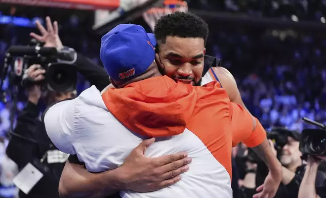 New York Knicks center Karl-Anthony Towns hugs his dad, Karl Towns, Sr., following Game 1 in an NBA basketball first-round playoff series against the Detroit Pistons, Saturday, April 19, 2025, in New York. (AP Photo/Julia Demaree Nikhinson)