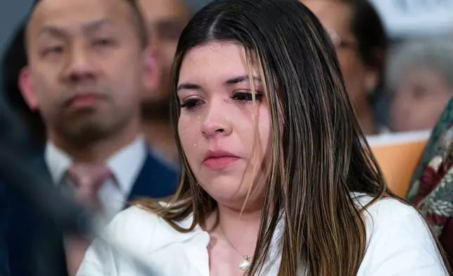 Jennifer Vasquez Sura cries as Sen. Chris Van Hollen, D-Md., speaks during a news conference upon his arrival from meeting with her husband Kilmar Abrego Garcia in El Salvador, at Washington Dulles International Airport, in Chantilly, Va., Friday, April 18, 2025. (AP Photo/Jose Luis Magana)