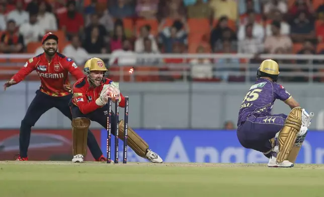 Punjab Kings wicketkeeper Josh Inglis, center, breaks the stumps to dismiss Kolkata Knight Riders' Rinku Singh, right, during the Indian Premier League cricket match between Punjab Kings and Kolkata Kings Riders at Maharaja Yadavindra Singh Cricket Stadium in Mohali, India, Tuesday, April 15, 2025. (AP Photo/Surjeet Yadav)