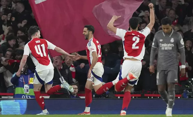 Arsenal's Mikel Merino, second left, celebrates with his teammate Declan Rice after scoring his side's third goal during the Champions League quarterfinal first leg soccer match between Arsenal and Real Madrid at the Emirates Stadium in London, Tuesday, April 8, 2025. (AP Photo/Frank Augstein)