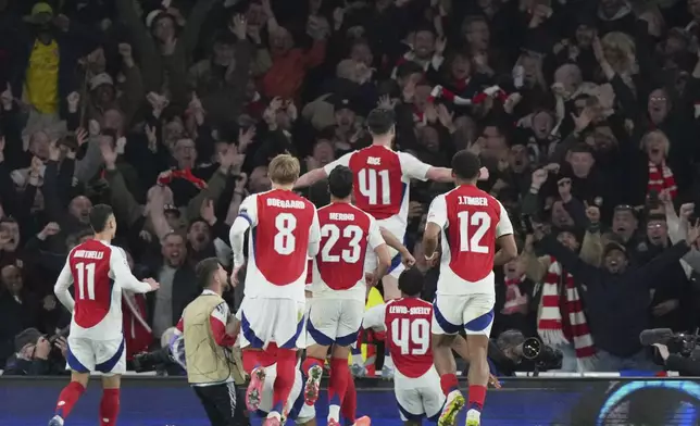Arsenal's Declan Rice, top, celebrates after scoring his side's second goal during the Champions League quarterfinal first leg soccer match between Arsenal and Real Madrid at the Emirates Stadium in London, Tuesday, April 8, 2025. (AP Photo/Frank Augstein)