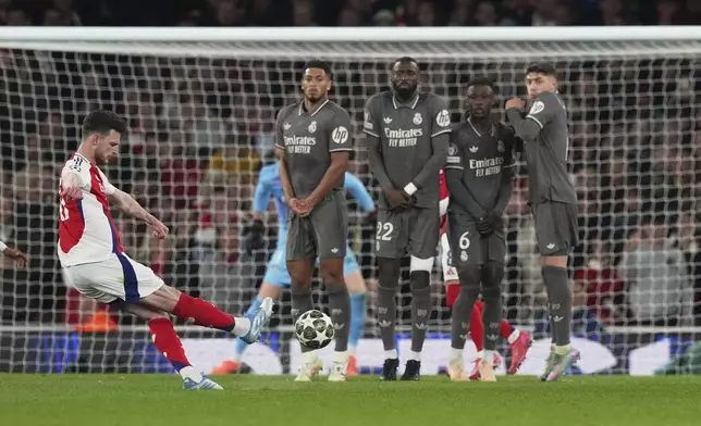 Arsenal's Declan Rice, left, scores his side's opening goal during the Champions League quarterfinal first leg soccer match between Arsenal and Real Madrid at the Emirates Stadium in London, Tuesday, April 8, 2025. (AP Photo/Frank Augstein)