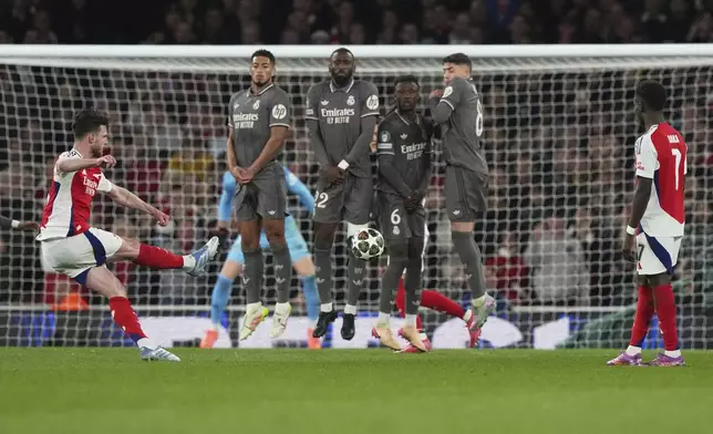 Arsenal's Declan Rice, left, scores his side's opening goal during the Champions League quarterfinal first leg soccer match between Arsenal and Real Madrid at the Emirates Stadium in London, Tuesday, April 8, 2025. (AP Photo/Frank Augstein)