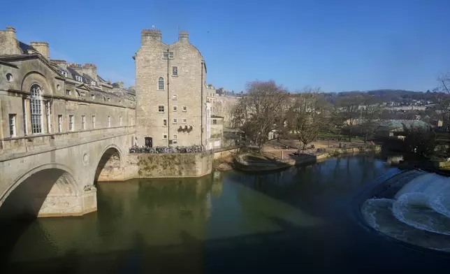 The Pulteney Bridge in the World Heritage site of Bath, England, is shown, Wednesday, March 5, 2025, with the rugby stadium to the right. (AP Photo/Frank Augstein)