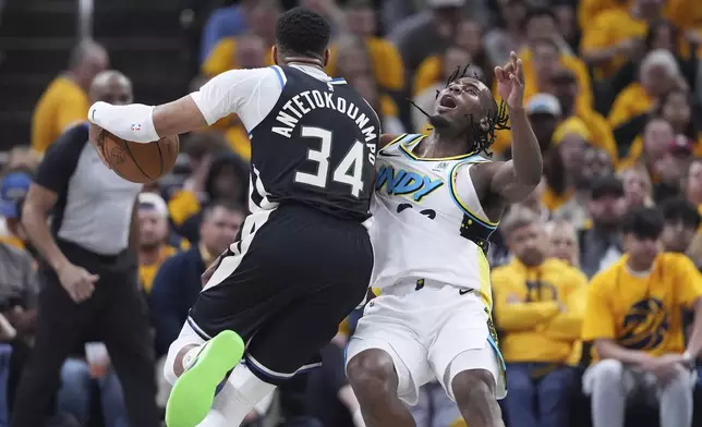 Milwaukee Bucks' Giannis Antetokounmpo (34) collides with Indiana Pacers' Aaron Nesmith during the first half of a first-round NBA basketball playoff game, Saturday, April 19, 2025, in Indianapolis. (AP Photo/Michael Conroy)
