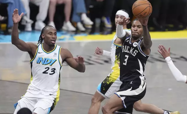 Milwaukee Bucks' Kevin Porter Jr. (3) passes as Indiana Pacers' Aaron Nesmith (23) watches during the first half of a first-round NBA basketball playoff game, Saturday, April 19, 2025, in Indianapolis. (AP Photo/Michael Conroy)