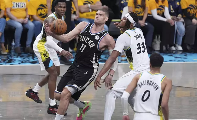 Milwaukee Bucks' Brook Lopez (11) heads to the basket past Indiana Pacers' Myles Turner (33) during the first half of a first-round NBA basketball playoff game, Saturday, April 19, 2025, in Indianapolis. (AP Photo/Michael Conroy)