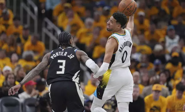 Indiana Pacers' Tyrese Haliburton (0) looks to pass as Milwaukee Bucks' Kevin Porter Jr. (3) defends during the second half of a first-round NBA basketball playoff game, Saturday, April 19, 2025, in Indianapolis. (AP Photo/Michael Conroy)