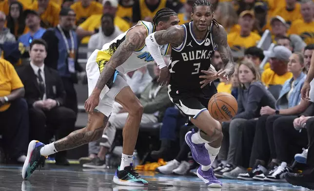 Milwaukee Bucks' Kevin Porter Jr. (3) and Indiana Pacers' Obi Toppin Cheerleaders perform during the second half of a first-round NBA basketball playoff game, Saturday, April 19, 2025, in Indianapolis. (AP Photo/Michael Conroy)