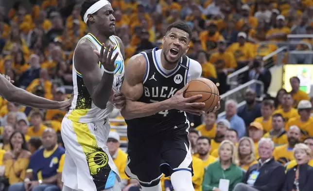 Milwaukee Bucks' Giannis Antetokounmpo, right, heads to the basket as Indiana Pacers' Pascal Siakam defends during the second half of a first-round NBA basketball playoff game, Saturday, April 19, 2025, in Indianapolis. (AP Photo/Michael Conroy)