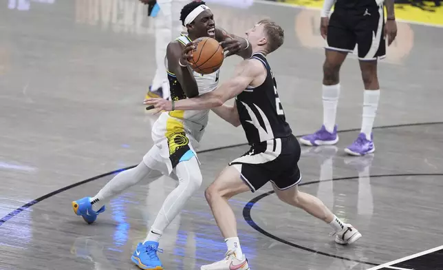 Indiana Pacers' Pascal Siakam, left, is stopped by Milwaukee Bucks' AJ Green during the second half of a first-round NBA basketball playoff game, Saturday, April 19, 2025, in Indianapolis. (AP Photo/Michael Conroy)