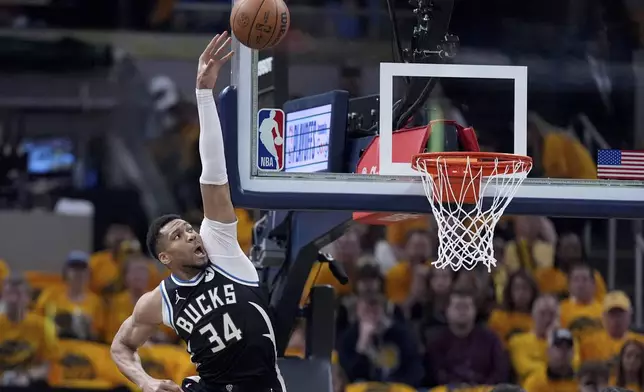 Milwaukee Bucks' Giannis Antetokounmpo (34) reaches for a rebound during the first half of a first-round NBA basketball playoff game against the Indiana Pacers, Saturday, April 19, 2025, in Indianapolis. (AP Photo/Michael Conroy)