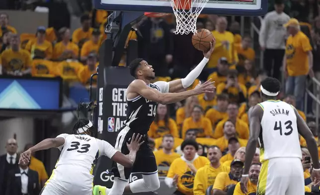 Milwaukee Bucks' Giannis Antetokounmpo (34) heads to the basket as Indiana Pacers' Myles Turner (33) and Pascal Siakam (43) defend during the first half of a first-round NBA basketball playoff game, Saturday, April 19, 2025, in Indianapolis. (AP Photo/Michael Conroy)