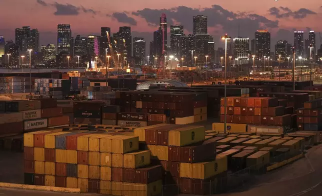 Shipping containers sit stacked at PortMiami, in front of the downtown Miami skyline, at sunset on Wednesday, April 16, 2025. (AP Photo/Rebecca Blackwell)