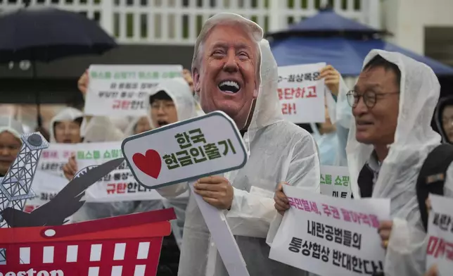 A protester wearing mask of U.S. President Donald Trump, center, attends a news conference against Trump's tariffs policy and demand South Korean acting President Han Duck-soo and Finance Minister Choi Sang-mok to resign, in Seoul, South Korea, Tuesday, April 22, 2025. (AP Photo/Lee Jin-man)