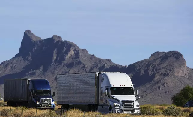 Freight trucks travel along Interstate 10, Thursday, April 17, 2025, in Picacho, Ariz. (AP Photo/Ross D. Franklin)