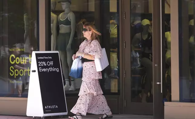 A shopper leaves an Athleta store, Friday, April 18, 2025, in Miami Beach, Fla. (AP Photo/Marta Lavandier)