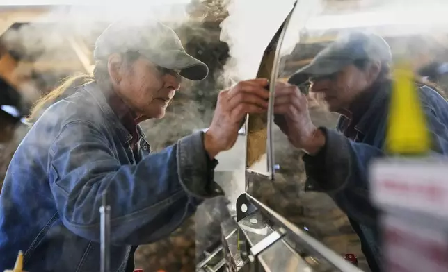Donna Young checks the Canadian-made maple syrup evaporator in the sugarhouse at Judd's Wayeeses Farms in Morgan, Vt., on Friday, April 11, 2025. (AP Photo/Robert F. Bukaty)