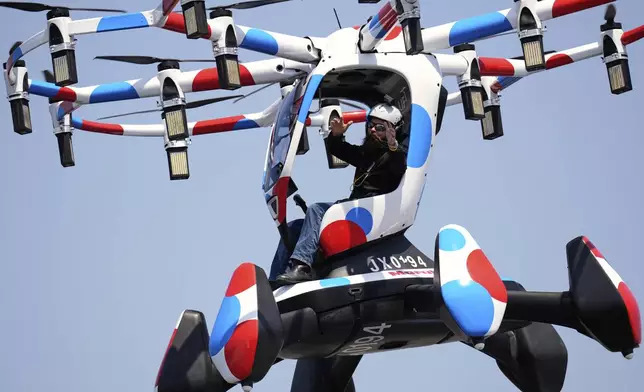 A pilot in a Hexa battery-powered aircraft shows his hands not on the joystick during its demonstration at the Expo 2025 in Osaka, western Japan, Monday, April 14, 2025. (AP Photo/Hiro Komae)