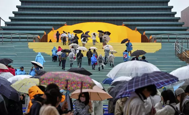 People visit Spain's pavilion on the opening day of the Expo 2025 in Osaka, central Japan, in the rain Sunday, April 13, 2025. (AP Photo/Hiro Komae)