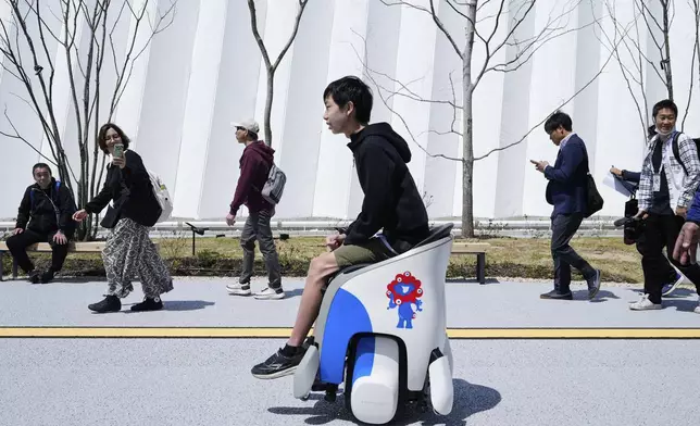 A visitor tries experiencing to maneuver UNI-ONE electric mobility devices built by Honda, dubbing the ride as "hands-free personal mobility devices," during the Expo 2025 in Osaka, western Japan, Monday, April 14, 2025. (AP Photo/Hiro Komae)