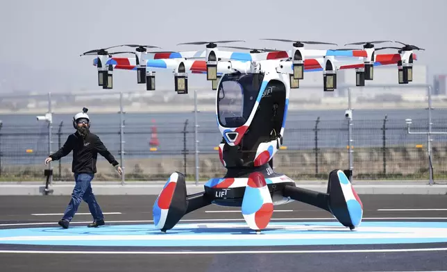 A pilot walks around a Hexa battery-powered aircraft before taking off during its demonstration at the Expo 2025 in Osaka, western Japan, Monday, April 14, 2025. (AP Photo/Hiro Komae)