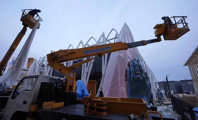 Workers try to put decorations on India's pavilion the day before the opening of the Expo 2025 in Osaka, central Japan, Saturday, April 12, 2025. (AP Photo/Hiro Komae)