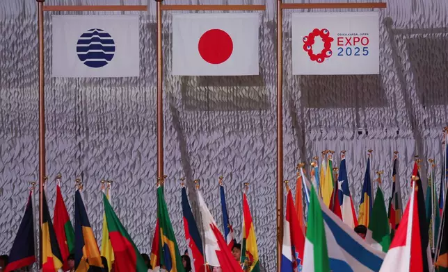 From left, flags of the Bureau International des Expositions (BIE), Japan and Osaka Expo 2025 are seen during the opening ceremony of the expo in Osaka, western Japan Saturday, April 12, 2025. (Jia Haocheng/Pool Photo via AP)