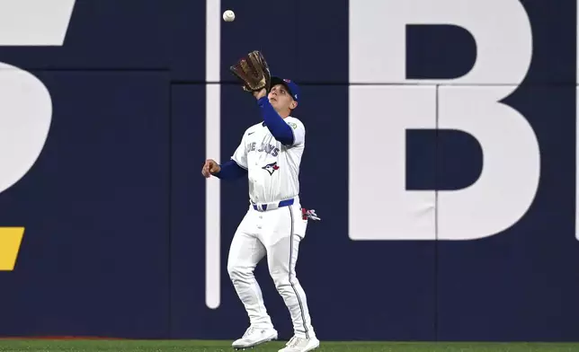 Toronto Blue Jays center fielder Daulton Varsho (5) catches a fly ball off the bat of Boston Red Sox's Triston Casas in the third inning of a baseball game in Toronto on Tuesday, April 29, 2025. (Jon Blacker/The Canadian Press via AP)