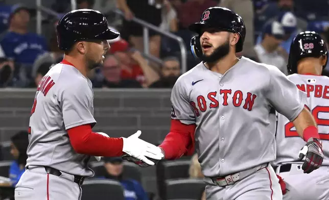 Boston Red Sox's Wilyer Abreu, right, and Alex Bregman (2) celebrate Abreu's three-run home run against the Toronto Blue Jays in the third inning of a baseball game in Toronto on Tuesday, April 29, 2025. (Jon Blacker/The Canadian Press via AP)